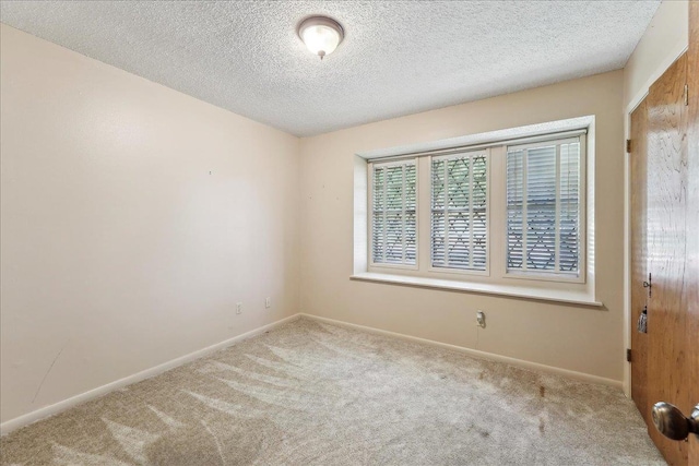 1004 Louise Dr, Nederland, TX 77627 - empty room with a textured ceiling, carpet flooring, and baseboards