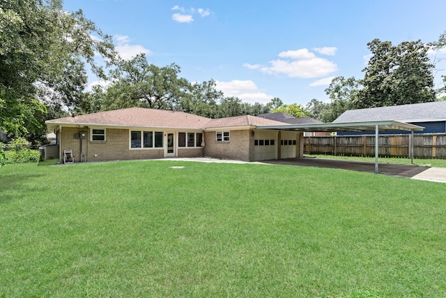 rear view of house featuring a carport, a garage, and a yard