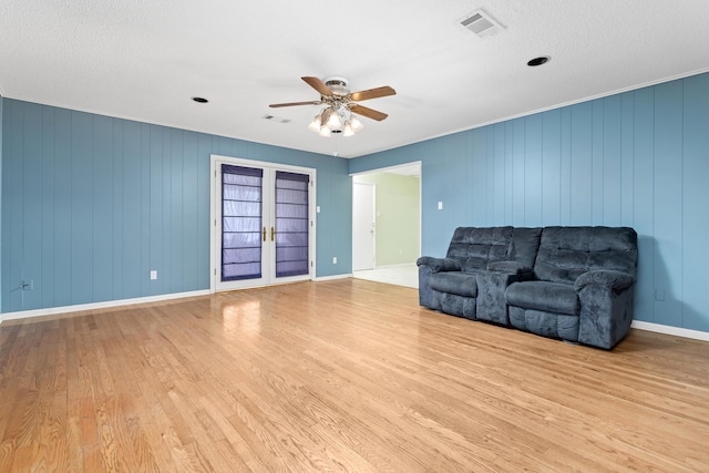 living room with ceiling fan, light hardwood / wood-style flooring, and french doors