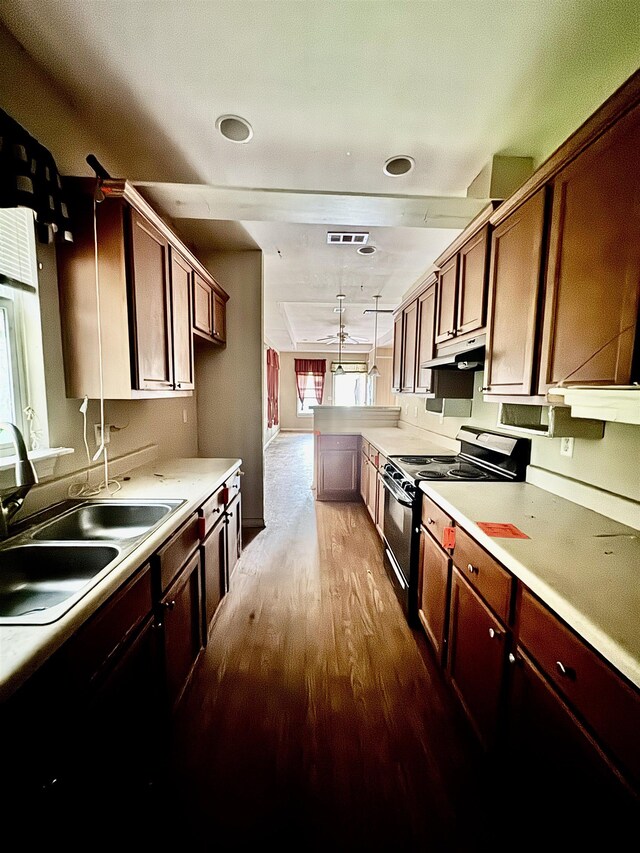 320 W Railroad Ave, China, TX 77613 - kitchen featuring black electric range oven, a peninsula, wood finished floors, under cabinet range hood, and light countertops