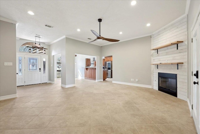 unfurnished living room with a large fireplace, ornamental molding, visible vents, and baseboards