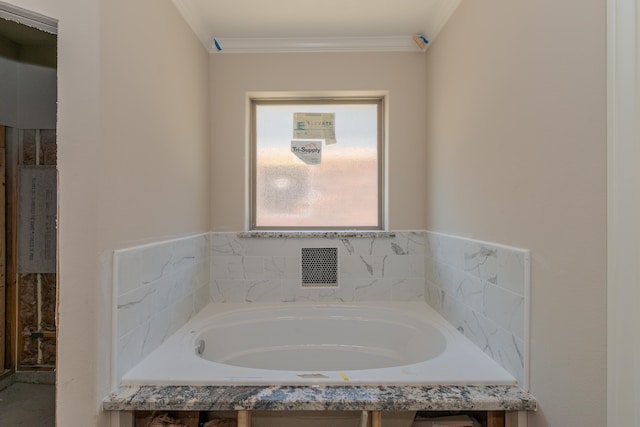 bathroom with a relaxing tiled tub and ornamental molding