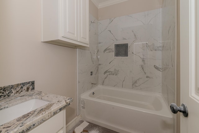 bathroom featuring tiled shower / bath, crown molding, and vanity