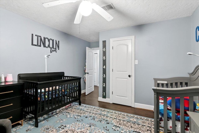 5880 Longwood St, Beaumont, TX 77707 - bedroom featuring wood finished floors, a textured ceiling, baseboards, ceiling fan, and a crib