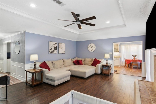 5880 Longwood St, Beaumont, TX 77707 - living area featuring a raised ceiling, a ceiling fan, hardwood / wood-style flooring, crown molding, and wainscoting