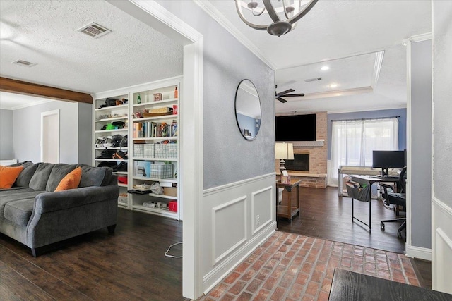 5880 Longwood St, Beaumont, TX 77707 - living room with crown molding, a ceiling fan, a large fireplace, a wainscoted wall, and baseboards