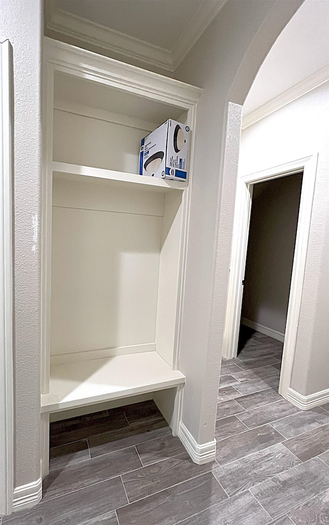 mudroom featuring arched walkways, ornamental molding, baseboards, and wood tiled floor