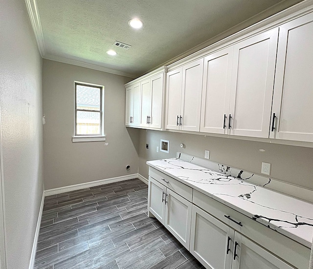 clothes washing area featuring cabinet space, visible vents, wood finish floors, washer hookup, and electric dryer hookup