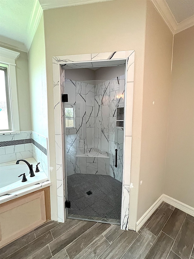 bathroom with ornamental molding, wood finish floors, a garden tub, and a marble finish shower