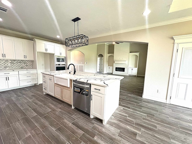 kitchen with arched walkways, a kitchen island with sink, white cabinets, appliances with stainless steel finishes, and wood tiled floor