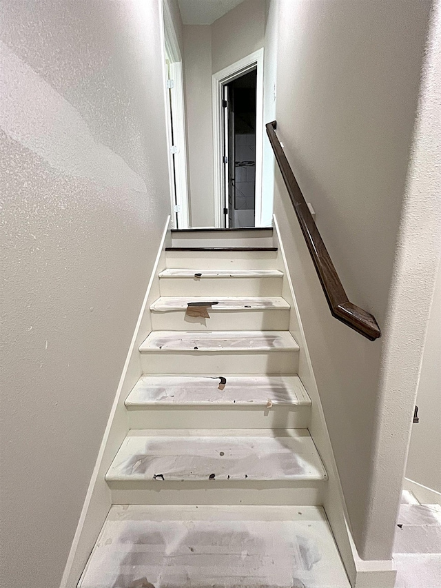 staircase featuring baseboards