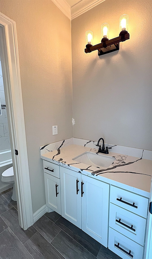 full bath featuring ornamental molding, wood finish floors, vanity, and toilet