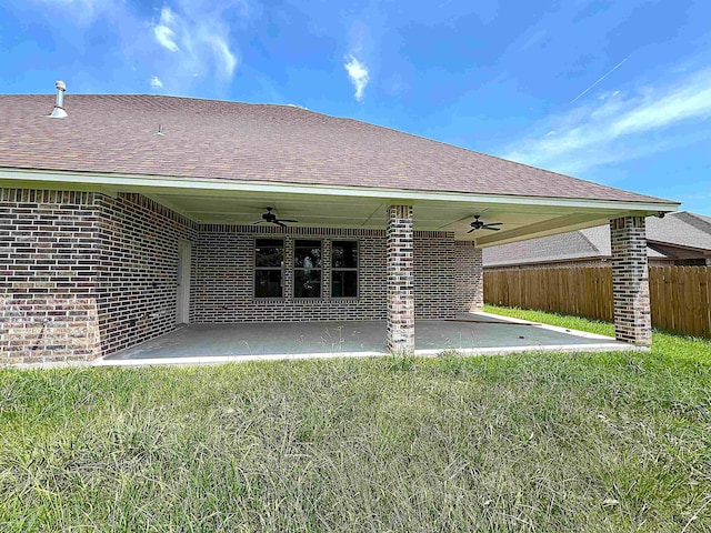 rear view of house featuring brick siding, fence, a ceiling fan, and a patio