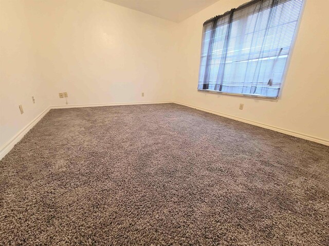 empty room with carpet flooring and baseboards