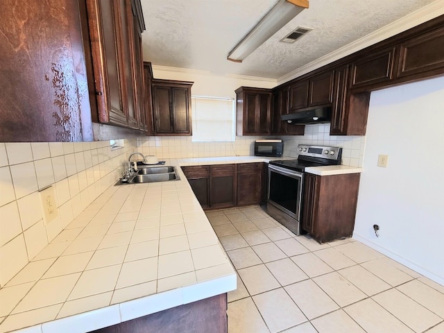 kitchen featuring under cabinet range hood, electric stove, tile countertops, a sink, and black microwave