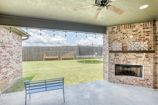 232 Spring Brook Ct, Lumberton, TX 77657 - view of patio with a trampoline, an outdoor brick fireplace, and a ceiling fan