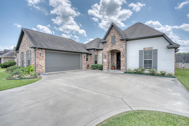 232 Spring Brook Ct, Lumberton, TX 77657 - french country style house featuring brick siding, roof with shingles, an attached garage, and driveway