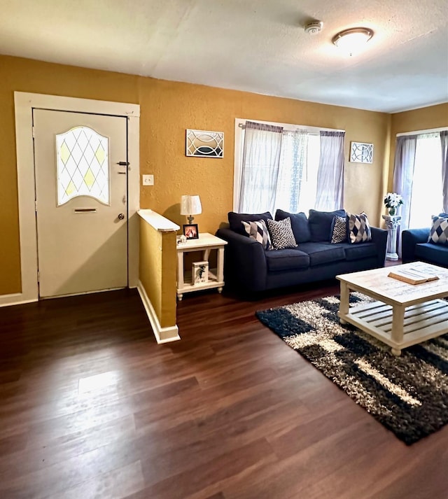 living room featuring a textured ceiling and dark wood-type flooring