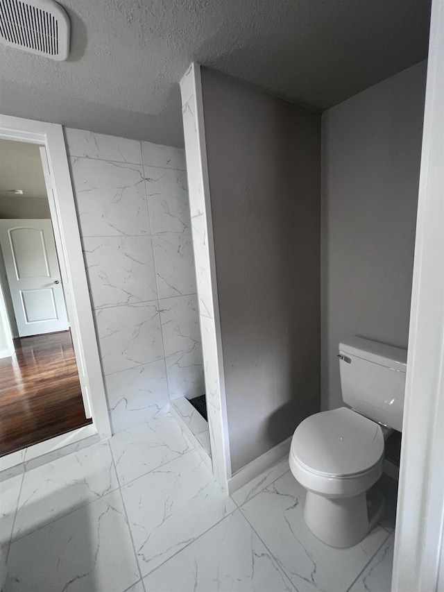 bathroom featuring toilet and a textured ceiling