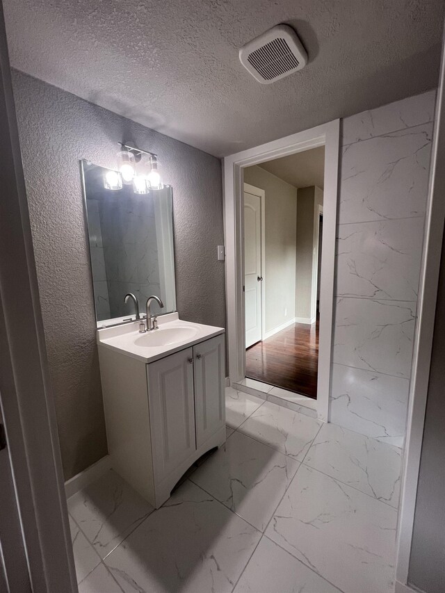 bathroom with vanity and a textured ceiling