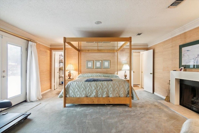 bedroom featuring carpet flooring, a textured ceiling, and crown molding