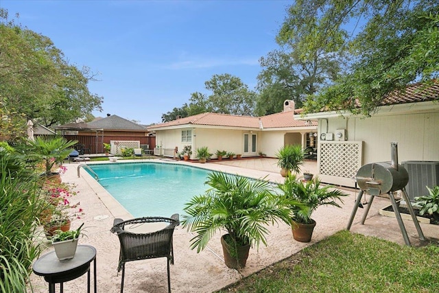 view of pool featuring cooling unit and a patio