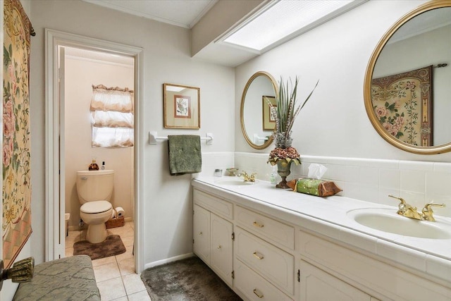 bathroom with a skylight, tile patterned flooring, backsplash, toilet, and vanity