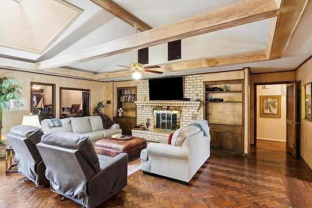 living room with built in shelves, ceiling fan, vaulted ceiling with beams, dark parquet floors, and a fireplace