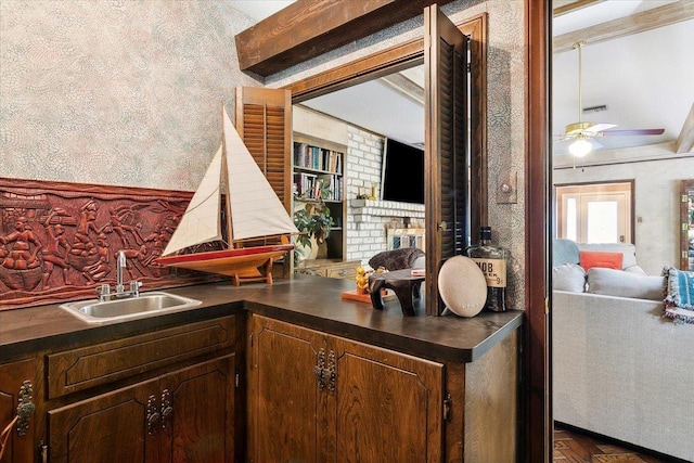 kitchen with dark brown cabinetry, ceiling fan, and sink