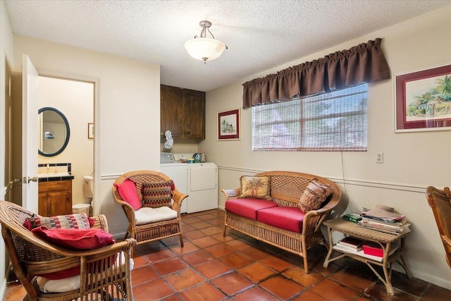 sitting room featuring washing machine and dryer and a textured ceiling