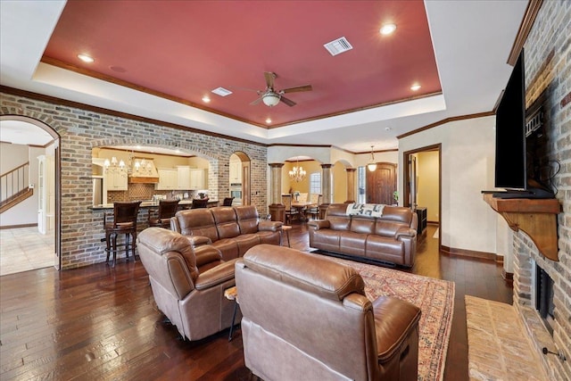 970 Hibiscus Cir, Beaumont, TX 77706 - living area featuring arched walkways, a tray ceiling, wood-type flooring, ceiling fan, and a stone fireplace