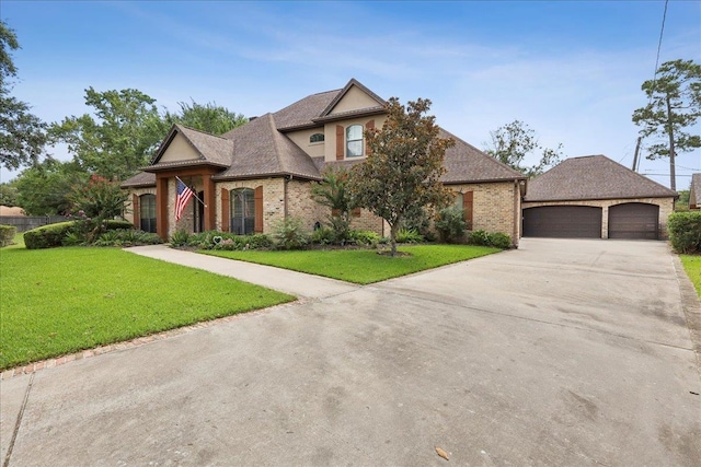 970 Hibiscus Cir, Beaumont, TX 77706 - french country style house featuring concrete driveway, a front yard, a garage, brick siding, and roof with shingles