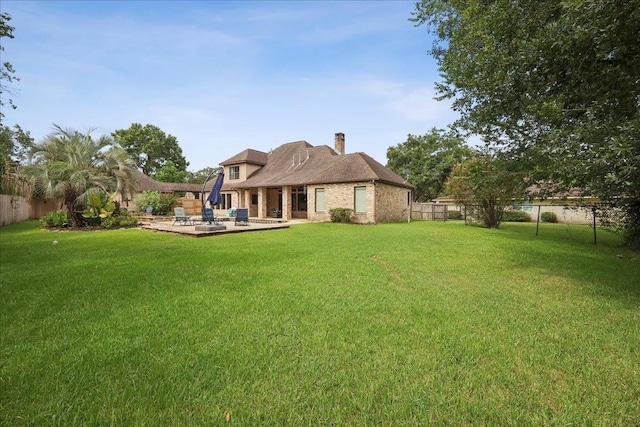 970 Hibiscus Cir, Beaumont, TX 77706 - rear view of house featuring a fenced backyard, a chimney, a patio area, and brick siding