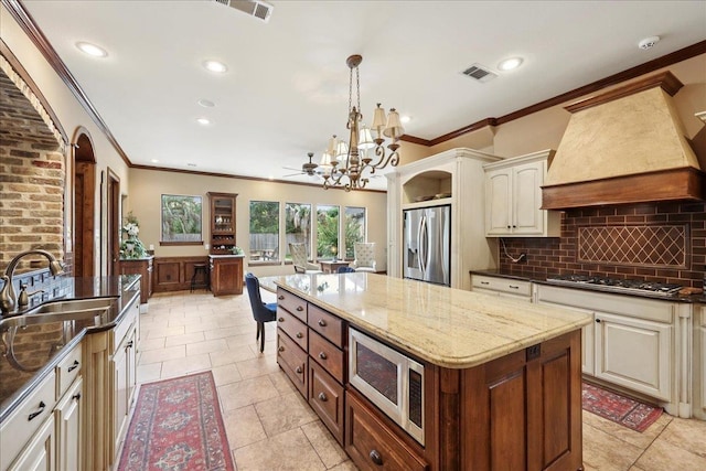 970 Hibiscus Cir, Beaumont, TX 77706 - kitchen with crown molding, backsplash, stainless steel appliances, a chandelier, and a center island