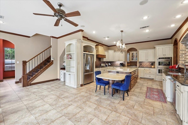970 Hibiscus Cir, Beaumont, TX 77706 - kitchen with arched walkways, ornamental molding, a center island, ceiling fan, and backsplash