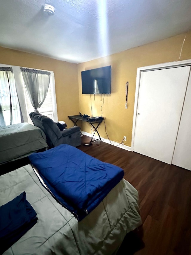 bedroom featuring baseboards and wood finished floors