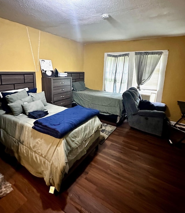 bedroom with wood finished floors and a textured ceiling