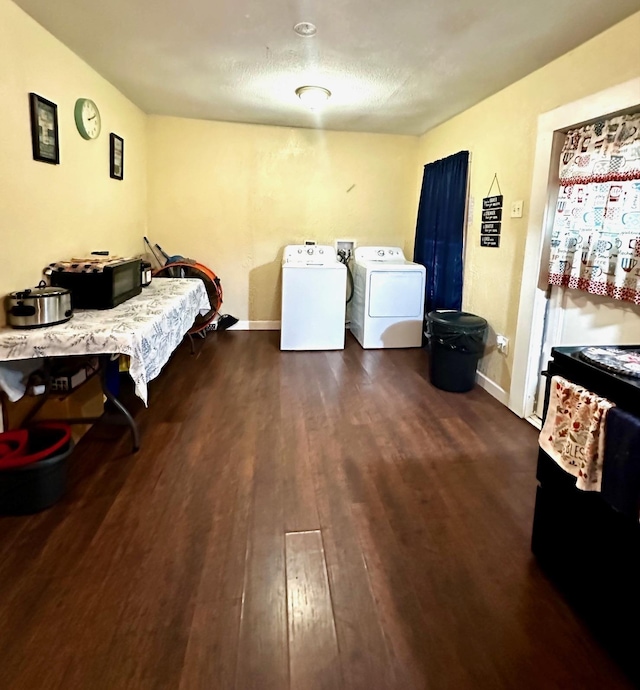 clothes washing area with washer and clothes dryer, laundry area, baseboards, and wood finished floors