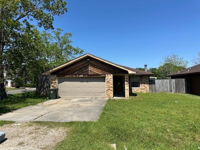 view of front of property featuring concrete driveway, a front yard, a garage, and fence