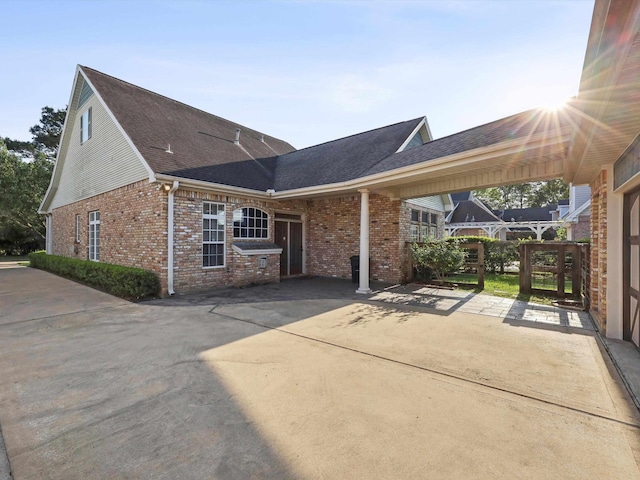 9670 Manion Ct, Beaumont, TX 77706 - view of side of home with concrete driveway, brick siding, a patio area, and roof with shingles
