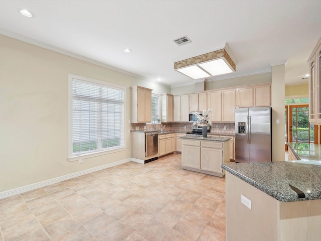 9670 Manion Ct, Beaumont, TX 77706 - kitchen featuring stainless steel appliances, visible vents, light brown cabinets, dark stone counters, and tasteful backsplash