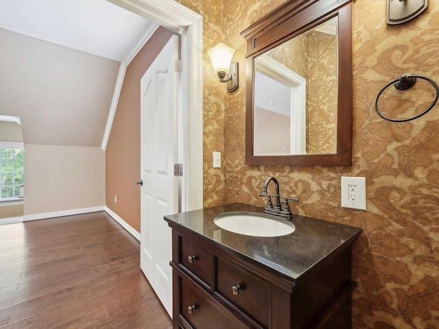 9670 Manion Ct, Beaumont, TX 77706 - bathroom with vaulted ceiling, wood finished floors, wallpapered walls, vanity, and baseboards