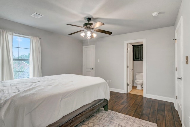 bedroom featuring dark hardwood / wood-style flooring, connected bathroom, and ceiling fan