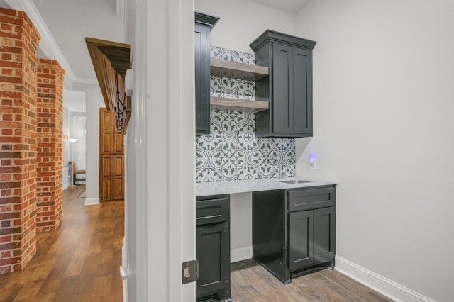 bar with gray cabinetry, crown molding, light hardwood / wood-style flooring, and tasteful backsplash