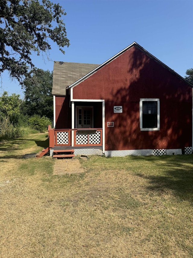 view of side of property with a lawn and a porch