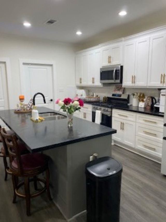 kitchen featuring white cabinets, sink, an island with sink, and appliances with stainless steel finishes