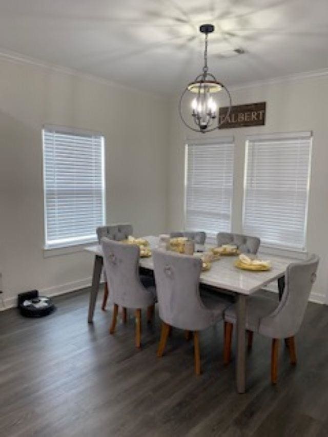 dining room featuring a chandelier, dark wood-type flooring, and ornamental molding