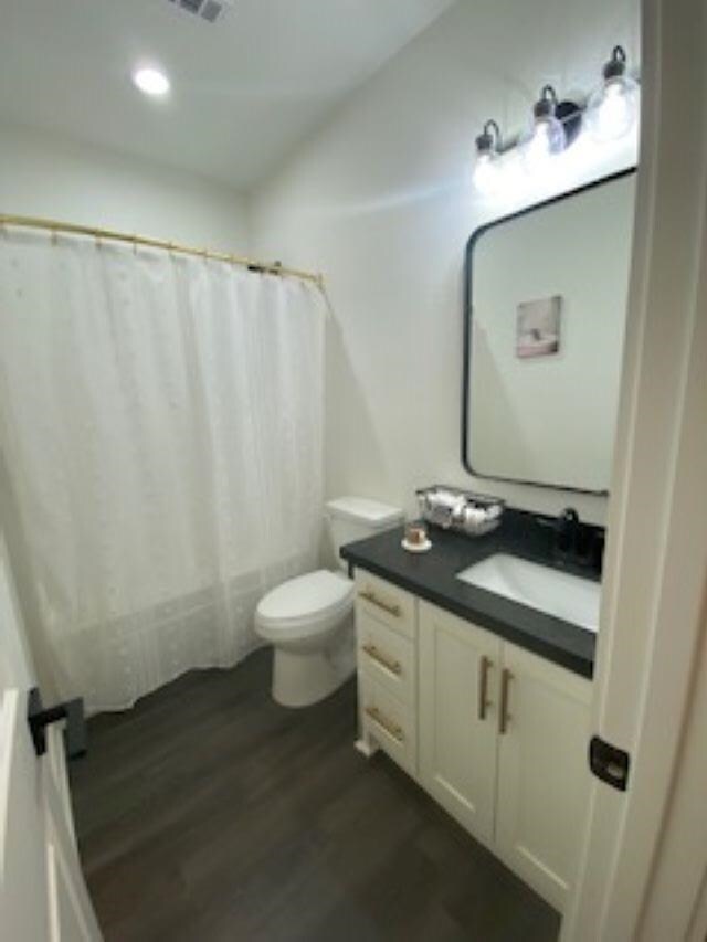 bathroom featuring hardwood / wood-style floors, vanity, and toilet