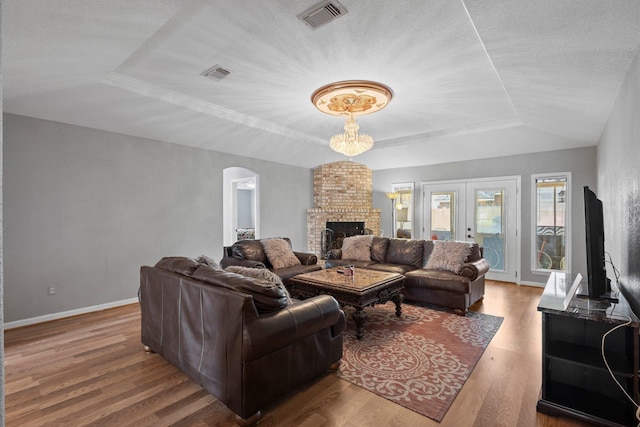 2515 Black Oak Dr, Orange, TX 77632 - living area featuring a raised ceiling, arched walkways, wood finished floors, baseboards, and a fireplace