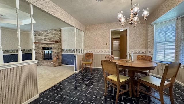 tiled dining room with a fireplace, a textured ceiling, and a notable chandelier